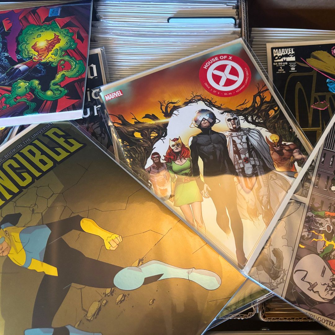 comic book collection scattered on table with Marvel and DC issues visible
